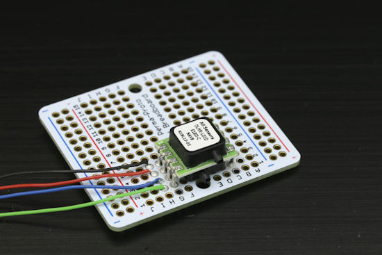 A DLHR-L01D differential pressure sensor, soldered on a breadboard